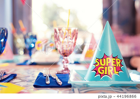 Close up of blue super girl party hat on the plate Close up of blue super girl party hat on the plate 44196866