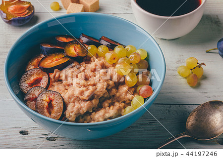 Porridge with fresh plum, grape and cup of coffee. Porridge with fresh plum, grape and cup of coffee. 44197246