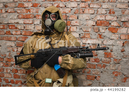 Stalker in gas mask with weapon near the brick wall Stalker in gas mask with weapon near the brick wall 44199282