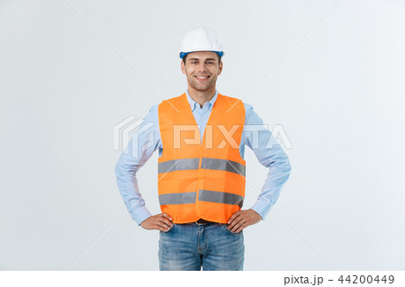 Portrait of a businessman or engineer in white helmet on gray background 44200449