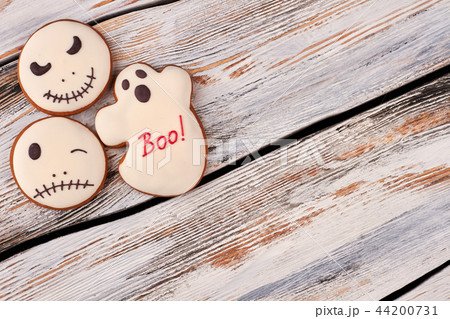 Halloween gingerbread cookies on wooden background. 44200731