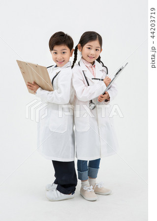 Children education. Young boy and girl wearing doctor uniform with stethoscope in white background 185 Children education. Young boy and girl wearing doctor uniform with stethoscope in white background 185 44203719