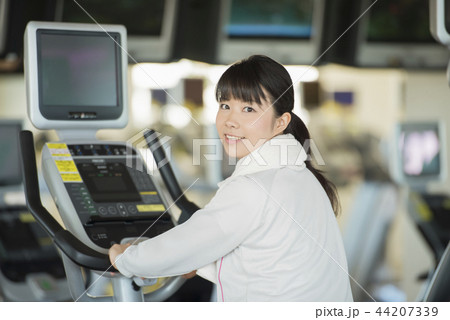ジムでエアロバイクに乗る女性 ジムでエアロバイクに乗る女性 44207339
