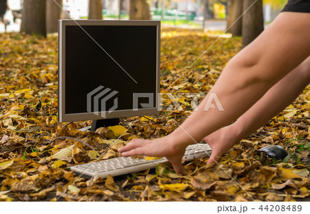 Autumn, a man working at a computer in the street Autumn, a man working at a computer in the street 44208489