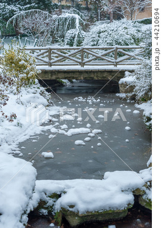 Frozen stream and little bridge under the snow in winter 44210694