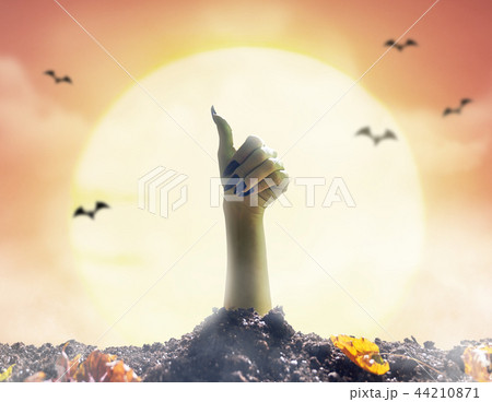 Zombie hand rising out of grave 44210871