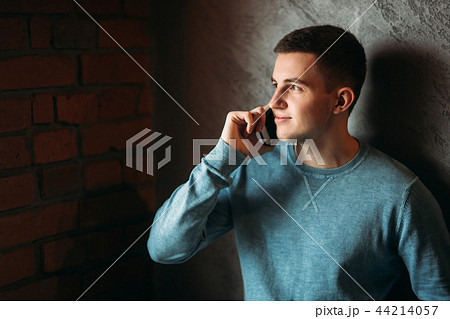 Man with phone in a cafe stand opposite the window. talking on the phone Man with phone in a cafe stand opposite the window. talking on the phone 44214057
