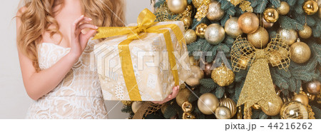 Happy woman opening gift box. Luxury blonde with Christmas gift. Merry Christmas and Happy New Year 44216262