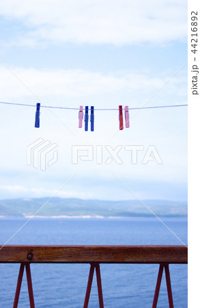 Clothespins hanging on clothesline and sea, island 44216892