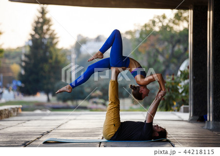 Young man and woman practicing acro yoga on street Young man and woman practicing acro yoga on street 44218115