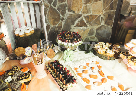 Delicious and tasty dessert table with cupcakes shots at reception closeup 44220041