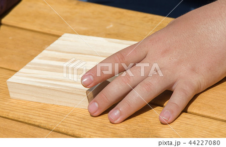 Hand holding wooden puzzle element in hand Hand holding wooden puzzle element in hand 44227080
