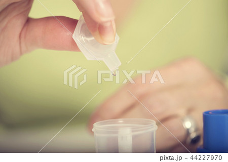 Female hand puts drug in a nebuliser container  44227970