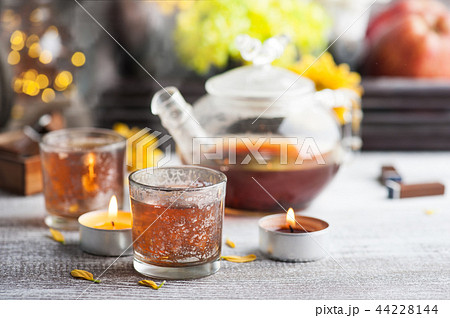 Glasses with lit candles and tea pot 44228144