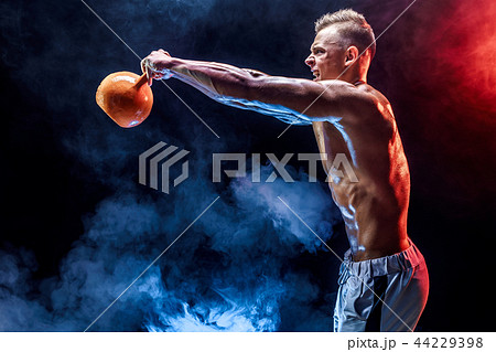 Concentrated muscular man doing exercise with kettlebell 44229398