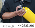 Unidentified people holding yellow oxygen tank. 44236190