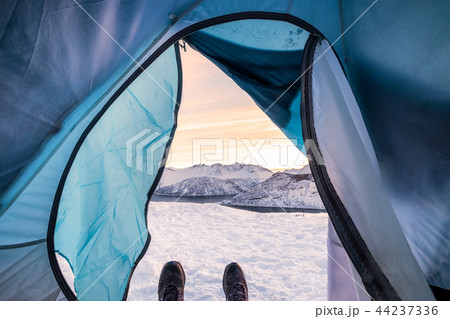 Snow boots relaxing inside tent camping entrance 44237336