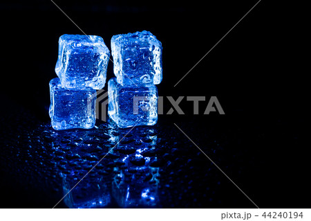 Blue ice cubes reflection on black table. Blue ice cubes reflection on black table. 44240194