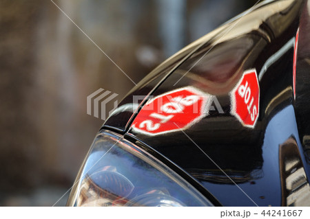 STOP signal over black vehicle hood with shallow depth of field STOP signal over black vehicle hood with shallow depth of field 44241667