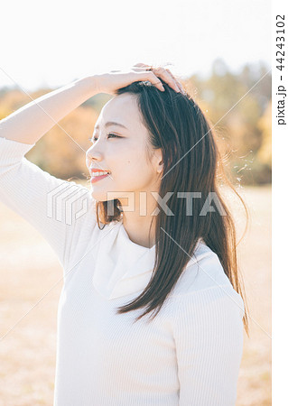 髪をかきあげる女性 44243102