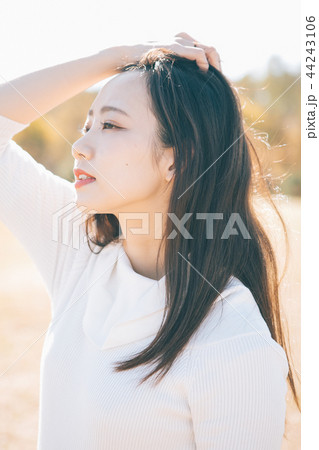 髪をかきあげる女性 44243106
