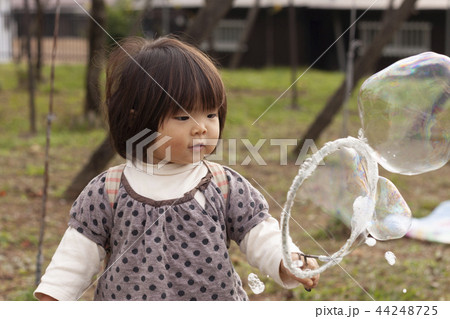 シャボン玉で遊ぶ女の子 44248725