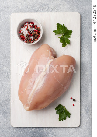 Raw chicken breasts and spices on wooden cutting Raw chicken breasts and spices on wooden cutting 44252549