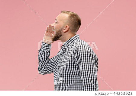 Isolated on pink young casual man shouting at studio 44253923