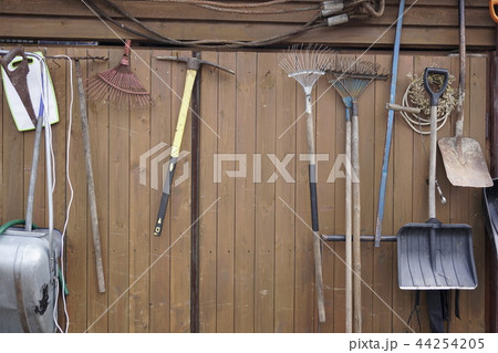 shovels rakes hammers hanging on wooden wall shovels rakes hammers hanging on wooden wall 44254205