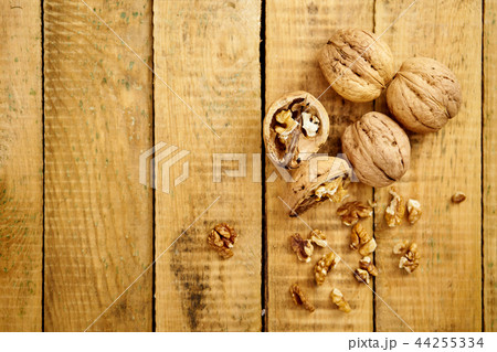 delicious and fresh crushed walnuts on a wooden table delicious and fresh crushed walnuts on a wooden table 44255334
