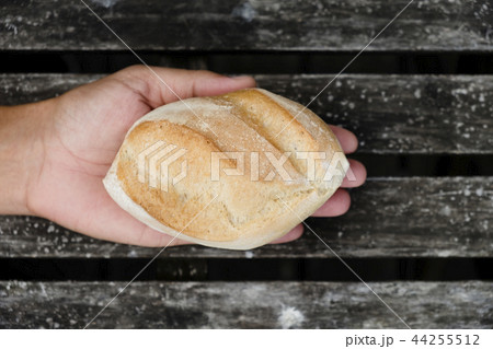 man with a bread roll in his hand 44255512