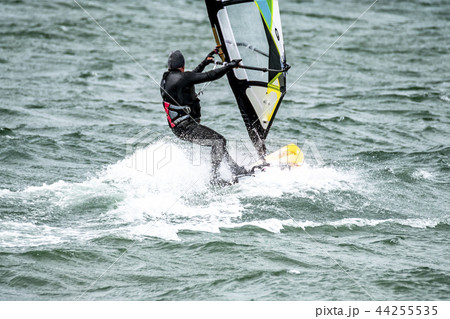 Man windsurfing close to the town of Caernarfon in Wales - United Kingdom 44255535