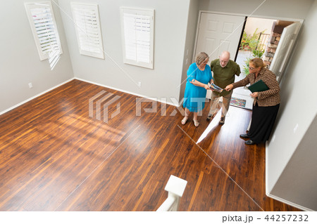 Real Estate Agent Shows Senior Couple A New Home Real Estate Agent Shows Senior Couple A New Home 44257232