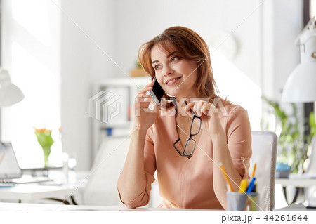 businesswoman calling on smartphone at office businesswoman calling on smartphone at office 44261644
