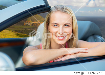 woman in convertible car on big sur coast 44261743