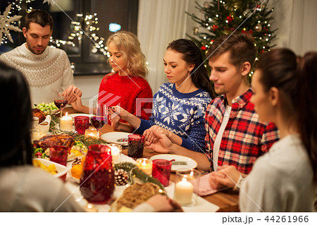 friends having home christmas dinner and praying 44261966