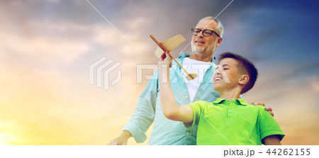 senior man and boy with toy airplane over sky 44262155