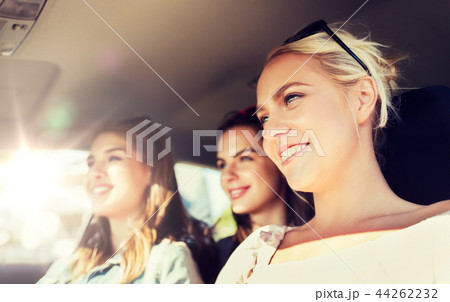 happy teenage girls or young women driving in car 44262232