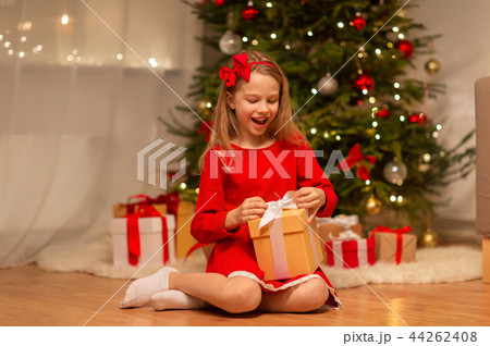 smiling girl with christmas gift at home smiling girl with christmas gift at home 44262408