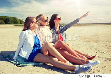 group of smiling women in sunglasses on beach 44262662