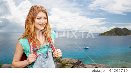 happy woman with backpack over seychelles island 44262719