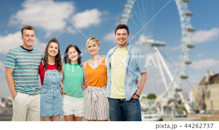 happy friends hugging over ferry wheel in london 44262737