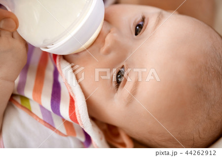 close up of baby sucking milk formula from bottle close up of baby sucking milk formula from bottle 44262912