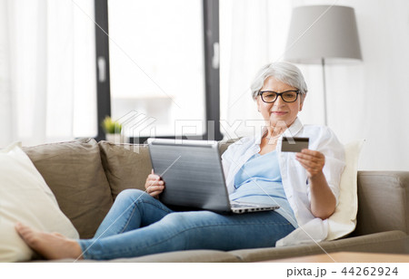 senior woman with laptop and credit card at home senior woman with laptop and credit card at home 44262924