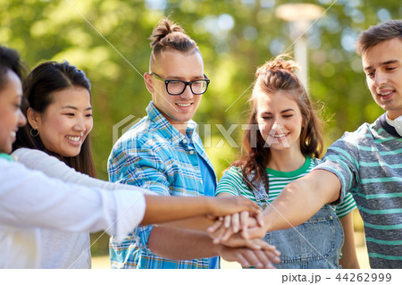 happy smiling friends stacking hands in park happy smiling friends stacking hands in park 44262999