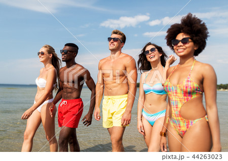 happy friends walking along summer beach 44263023