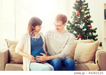 pregnant wife with husband at home at christmas 44263125