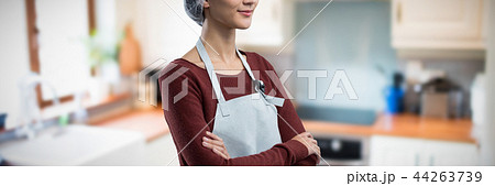 Composite image of thoughtful female chef standing with arms crossed Composite image of thoughtful female chef standing with arms crossed 44263739