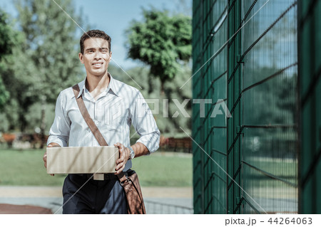 Serious male courier getting delivery in time 44264063