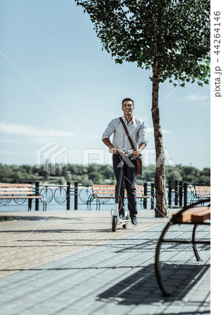 Optimistic energetic guy preferring mobile electric scooter 44264146